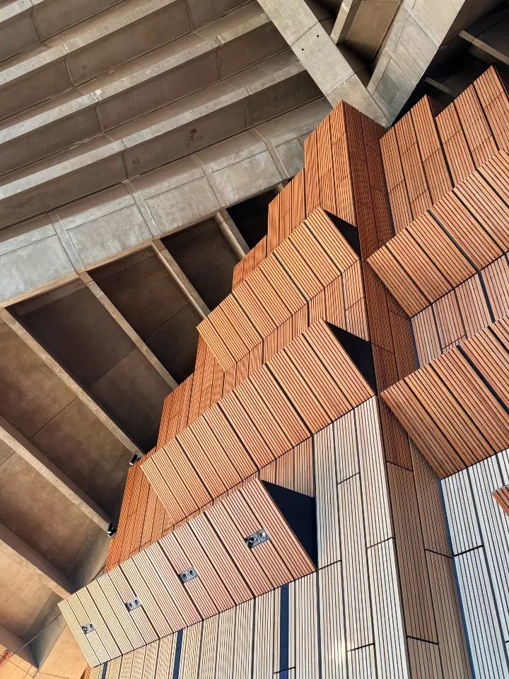 Close-up view of the Sydney Opera House's architectural details, featuring geometric patterns of timber and concrete elements.
